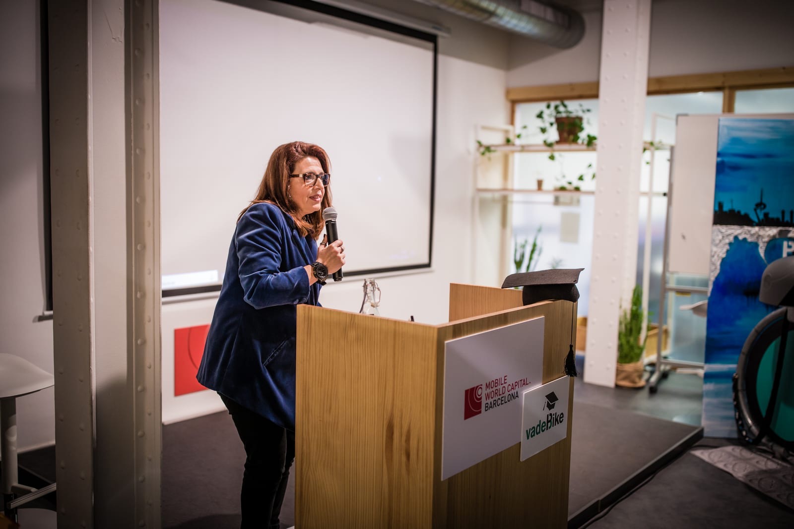 Integrante del equipo de vadeCity presentando el proyecto en una charla, ante un atril.
